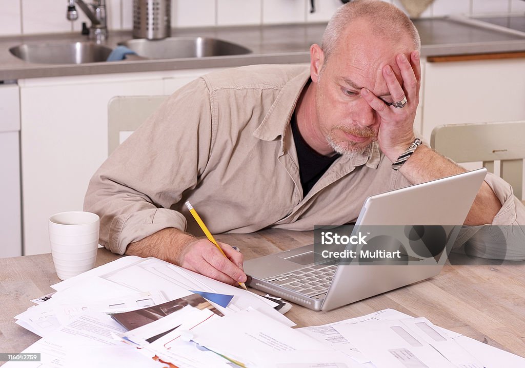 Man trying to pay the bills Sad man trying to pay all the bills at home Deadline Stock Photo