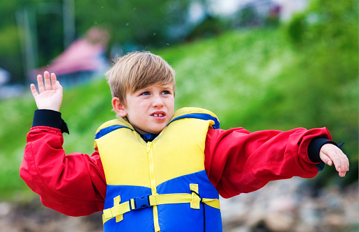 Young boy in life jacket fighting an onslaught of bugs on a Canadian Summer day