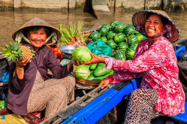 Vietnamese woman selling fruits on floating market, Mekong River Delta, Vietnam