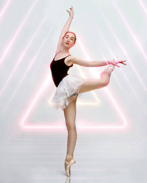 istock Young and incredibly beautiful ballerina is posing and dancing in a light grey studio full of light. The photo greatly reflects the incomparable beauty of a classical ballet art. 1160439216