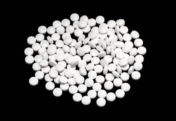istock Heap of white Pills isolated on black Background 1160439269