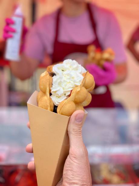 istock Man buying bubble waffle from food stall 1160444175