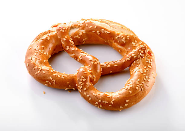 A collection of crispy breadsticks, or grissini, adorned with poppy seeds, against a warm brown background, capturing the golden texture and artisanal look of these snacks.