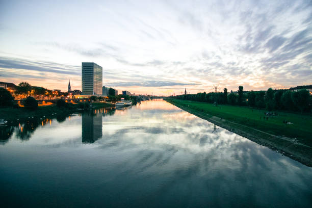 urban sunset with scenic sky and river scenic sunset over a river in a city in germany mannheim photos stock pictures, royalty-free photos & images