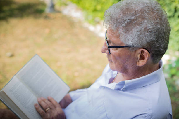 istock Senior man reading a book in the garden 1160468367