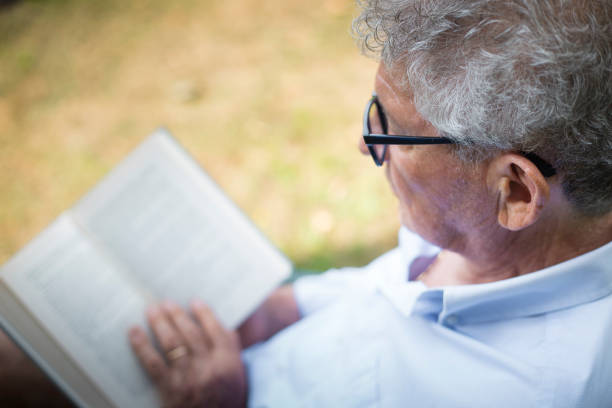 Senior man reading a book in the garden stock photo