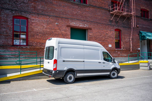 White compact popular cargo mini van for local deliveries and business standing on the warehouse parking lot White compact popular commercial economical cargo mini van for local deliveries and business specifications standing on the warehouse parking lot on the city street car transporter photos stock pictures, royalty-free photos & images