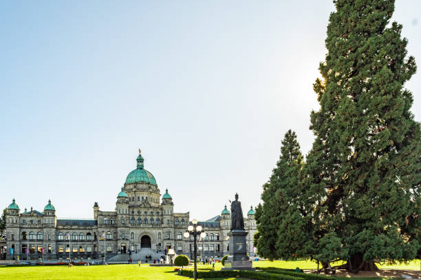 los edificios del parlamento de columbia británica, un diseño neobarroco, sede de la asamblea legislativa de bc. frente al edificio se encuentra la estatua de la reina victoria. - neobaroque fotografías e imágenes de stock