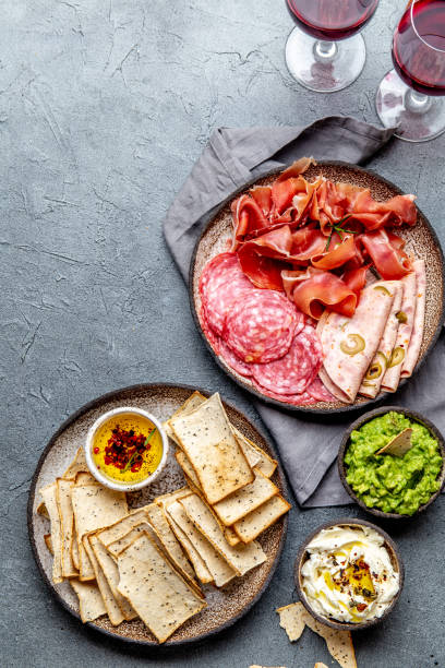 istock Antipasto. Meat platter, chips and sauces, red wine on gray background. Top view 1160479729