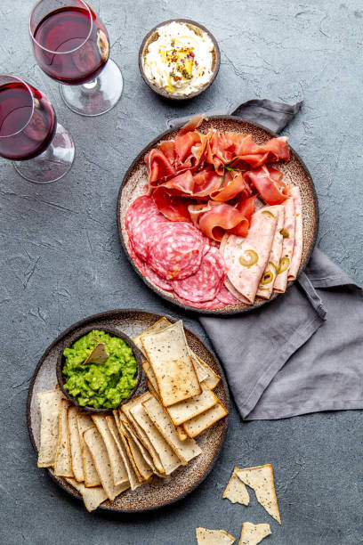 istock Antipasto. Meat platter, chips and sauces, red wine on gray background. Top view 1160479731