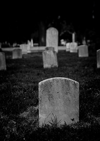 Black and white rendering of graveyards with tombstones in cemetery - spooky Halloween composition with space for names and inscriptions