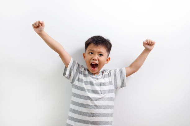 istock Boy (6-7) cheering, arms up, smiling 1160495761