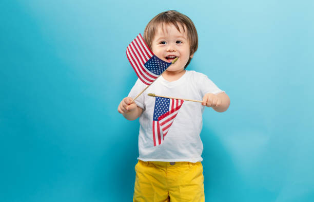 Young boy holding an american flag on a sunny day