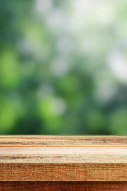 istock Blurred abstract green bokeh and wooden table background. 1160497893