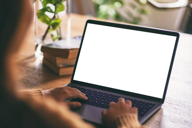een vrouw gebruiken en te typen op laptop met lege witte desktop scherm - laptop stockfoto's en -beelden