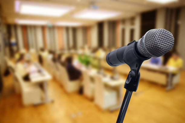istock Microphone over the blurred business forum Meeting or Conference Training Learning Coaching Room Concept, Blurred background. 1160509088
