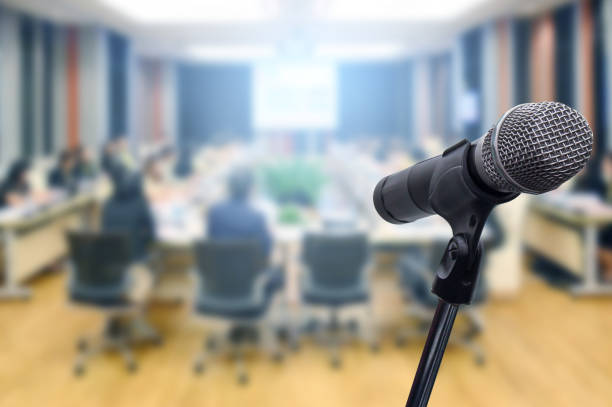 istock Microphone over the blurred business forum Meeting or Conference Training Learning Coaching Room Concept, Blurred background. 1160509113