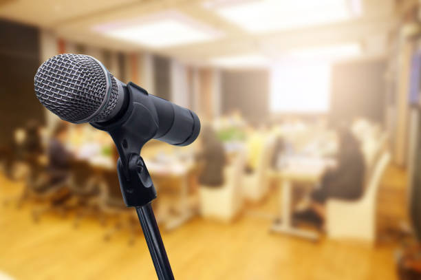 istock Microphone over the blurred business forum Meeting or Conference Training Learning Coaching Room Concept, Blurred background. 1160509123