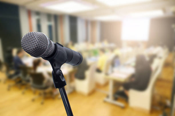 istock Microphone over the blurred business forum Meeting or Conference Training Learning Coaching Room Concept, Blurred background. 1160509129