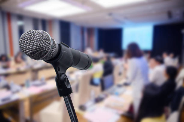 istock Microphone over the blurred business forum Meeting or Conference Training Learning Coaching Room Concept, Blurred background. 1160509144