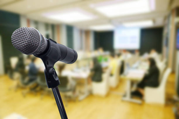 istock Microphone over the blurred business forum Meeting or Conference Training Learning Coaching Room Concept, Blurred background. 1160509145