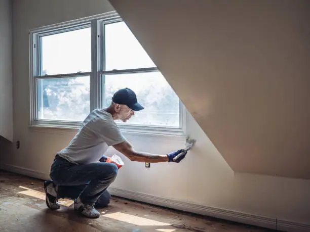 Photo of Senior man painting apartment interior