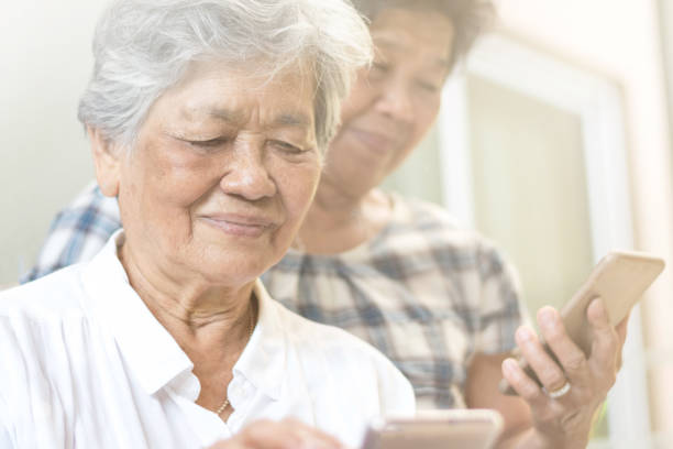 Happy elderly senior people society lifestyle technology concept. Ageing Asia women using tablet smartphone or mobile phone share social media together in wellbeing county home. concepto de tecnología de estilo de vida de la sociedad de ancianos adultos mayores feliz. envejeciendo asia mujeres usando tableta teléfono inteligente o teléfono móvil comparten las redes sociales juntos en el hogar del condado de bienestar.