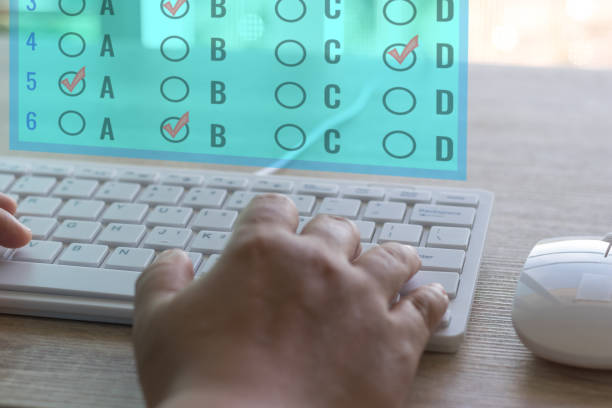Dry hand of adult student using white keyboard on table to do test examination with multiple choice questions on virtual screen at home. Education futuristic technology and Lifelong learning concept.