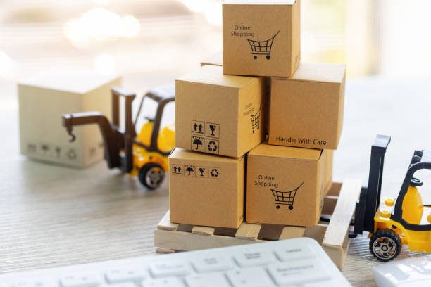 istock Mini forklift truck load stack of cardboard boxes with text online shopping and symbols on wooden pallet. Logistics and transportation management ideas and Industry business commercial concept. 1160513488