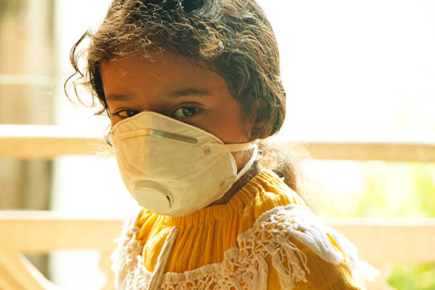 asian child girl wearning mask to save herself from the environmental air pollution - toxic substance fumes environment carbon dioxide imagens e fotografias de stock