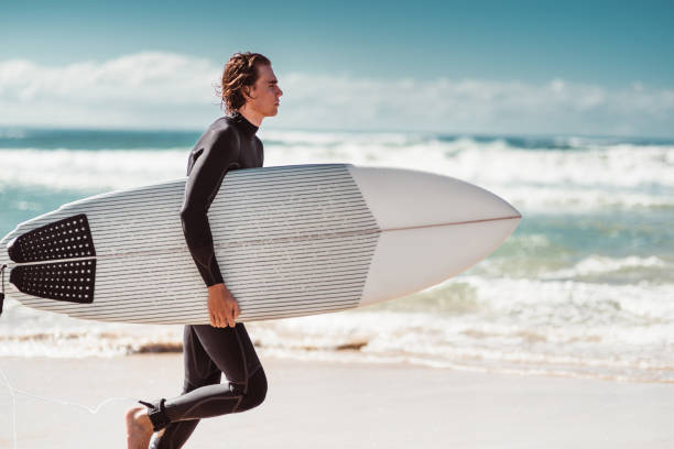 istock surfer running on the beach 1160521519