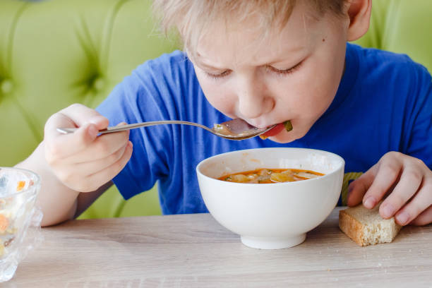 istock the little boy is appetizing eating a delicious soup 1160523352