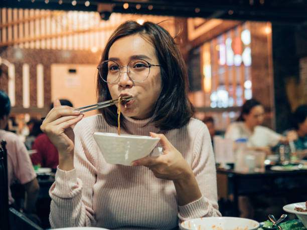 giovane donna asiatica che mangia buffet di barbecue coreano nel ristorante coreano. - buffet thai cuisine asian ethnicity food foto e immagini stock