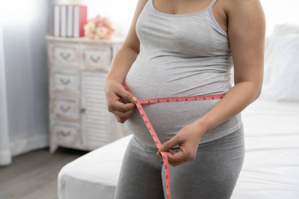 pregnant women are using a tape measure around the waist. - mother exercising baby dieting imagens e fotografias de stock