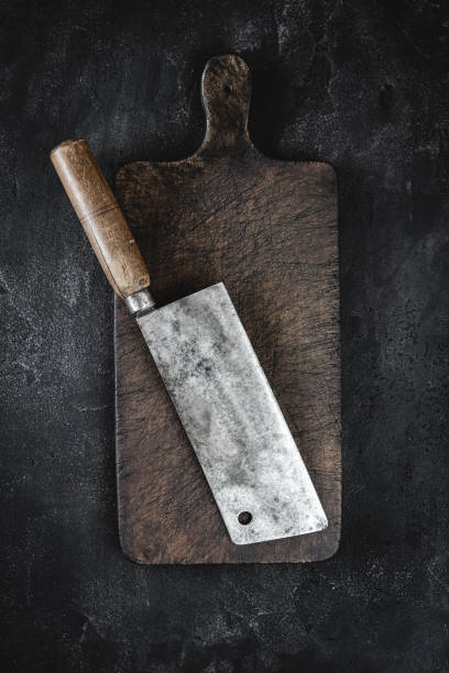 istock Rustic Cutting Board and Meat Cleaver on Dark Background 1160530176