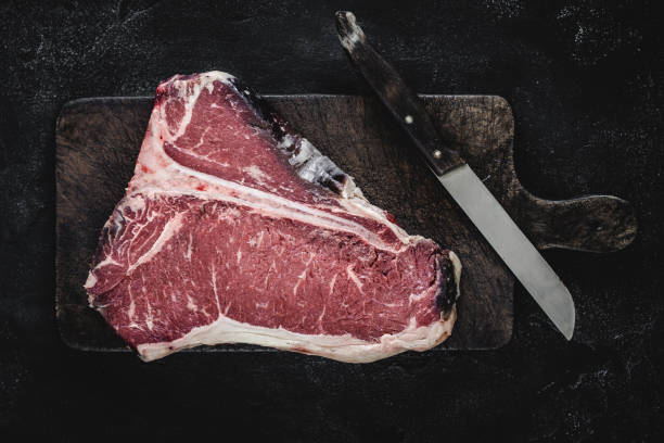 premium dry aged raw t-bone steak on rustic kitchen chopping board - veal t bone steak raw steak imagens e fotografias de stock