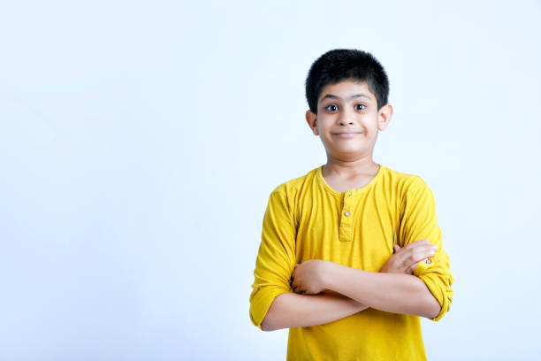 joven niño indio lindo de pie sobre el fondo blanco - child asian and indian ethnicities facial expression asia fotografías e imágenes de stock