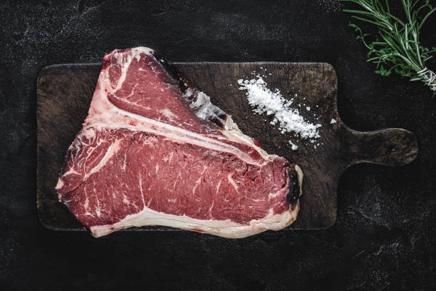 istock Dry Aged Beef Raw T-bone Steak on Vintage Cutting Board 1160530216