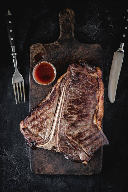 istock Barbecue Grilled Dry Aged Beef T-bone Steak on Rustic Cutting Board 1160530223
