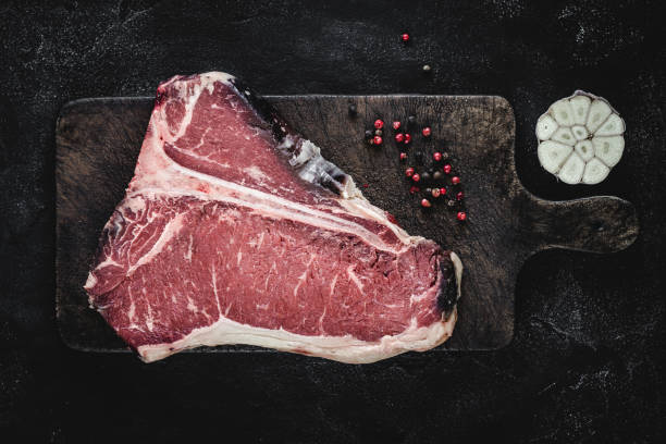istock Premium Dry Aged Raw T-bone Steak on Rustic Kitchen Chopping Board 1160530242