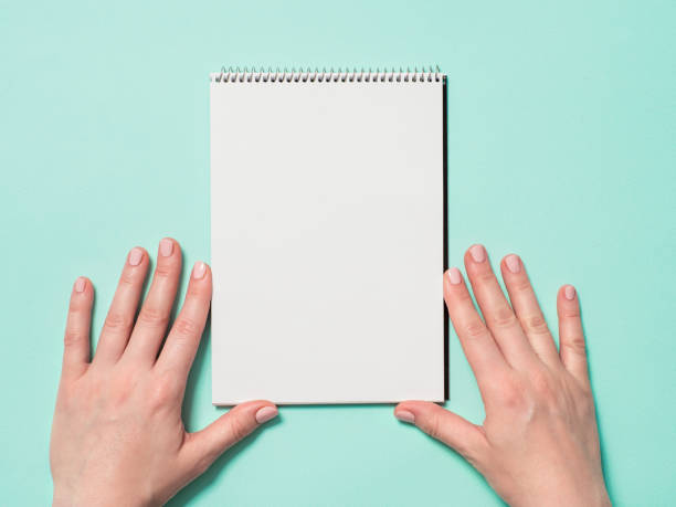 istock Blank paper notebook and female hands 1160533212