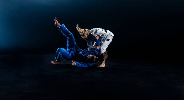 istock Female Judoka Throwing Her Partner To The Ground 1160533421