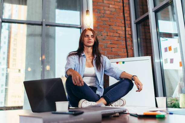 istock Female student sitting in lotus pose on table in her room meditating relaxing after studying and preparing for exam 1160533686