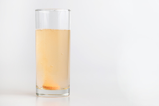 Disolver la tableta efervescente en un vaso de agua potable photo