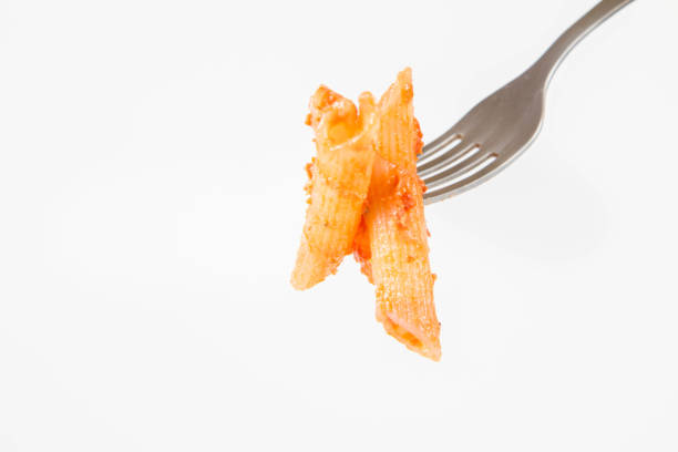 Penne with pesto eaten with a fork stock photo