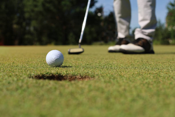 jogador de golfe no putting green que bate a esfera em um furo. - 2603 - fotografias e filmes do acervo