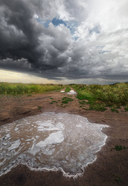 istock stormy sky over a summer field with a puddle in the foreground 1160536139