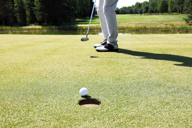 istock Golf player at the putting green hitting ball into a hole. 1160536273