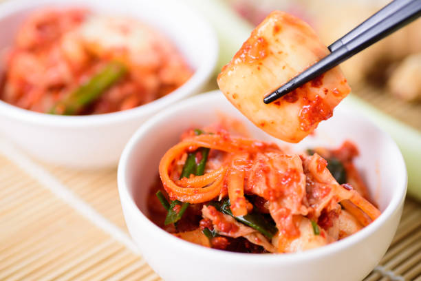 Eating kimchi cabbage in a bowl by chopsticks, Korean food