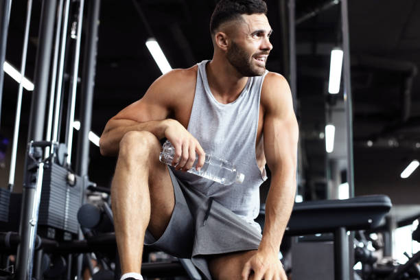 istock Sporty man resting, having break drinking water after doing exercise. 1160537556